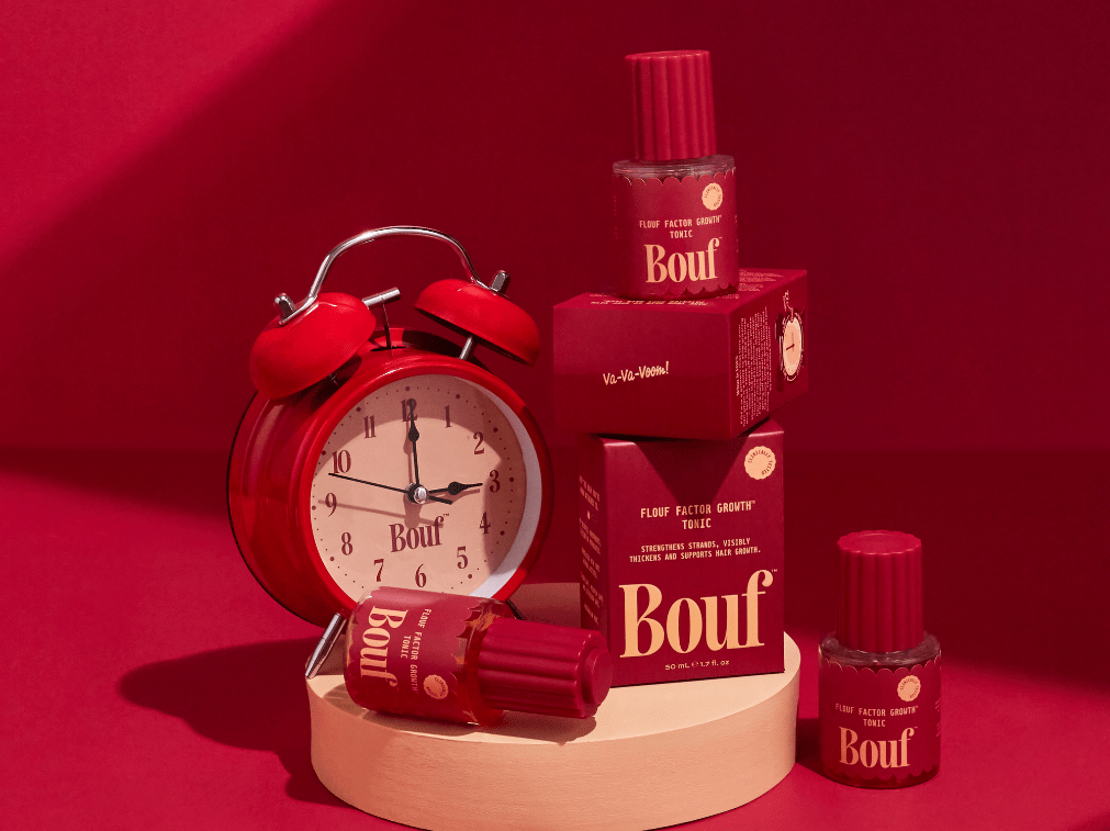 Red alarm clock and Bouf tonics on a red background