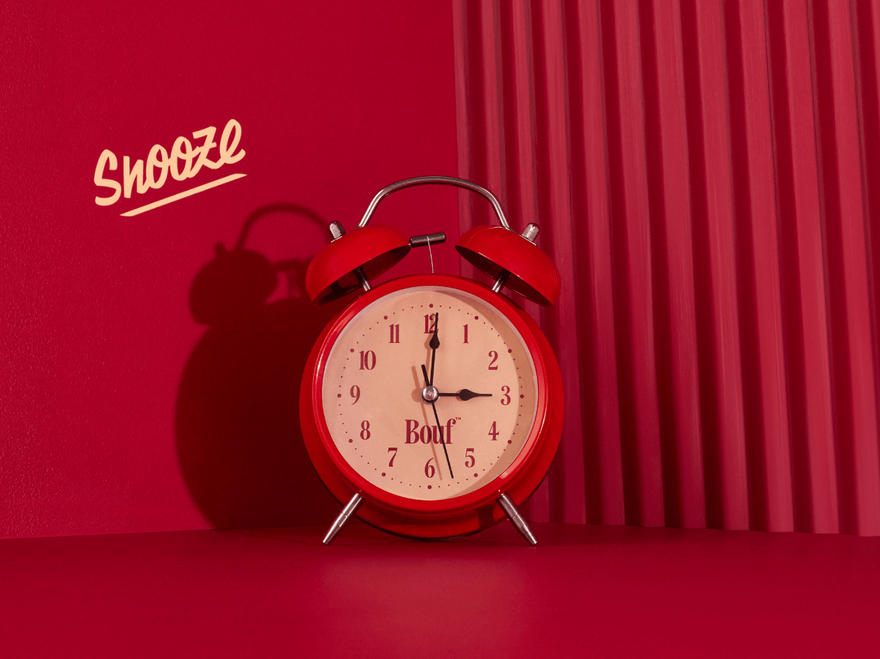 Red alarm clock with 'Snooze' text on a red background