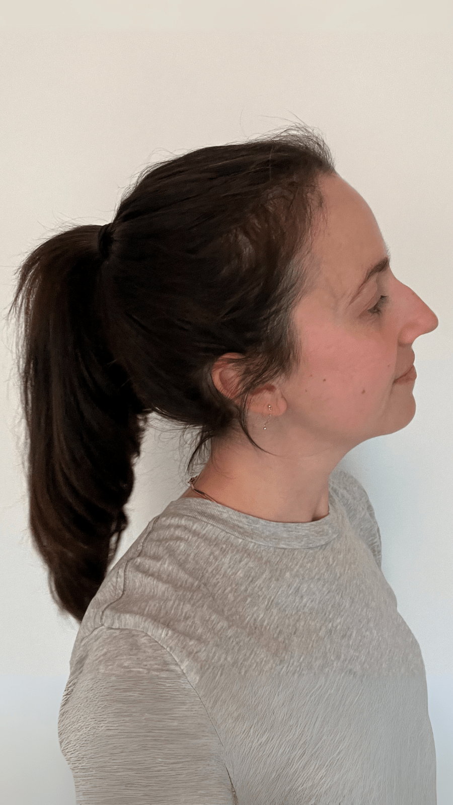 Woman with a ponytail showing her results against a white background.
