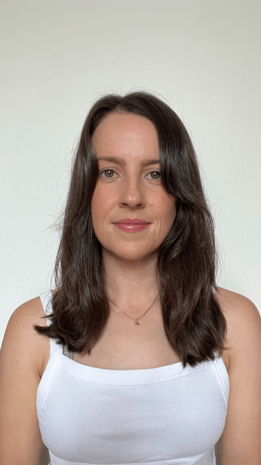 Woman with shoulder-length brown hair showing her results against a plain background.