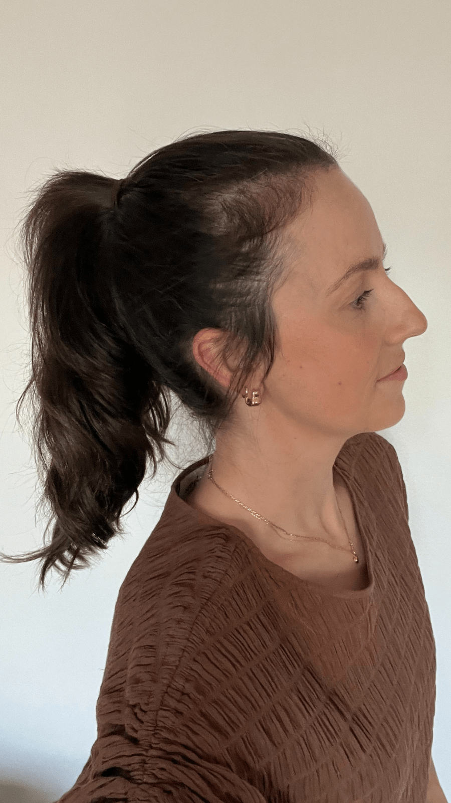 Woman with a ponytail showcasing her hair before using Bouf.